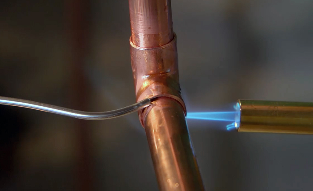 Soldering copper tube using torch for HVAC plumbing and industrial applications